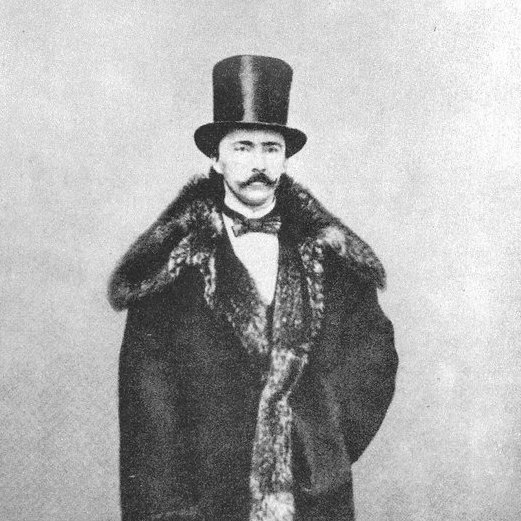 Porträt von Heinrich Schliemann in Hut und Mantel mit Pelzkragen, schwarz-weiß Fotografie.